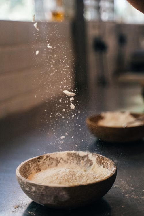 Flour falling into a handmade bowl